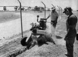 HARD AT WORK: Horsham Motor Sports Club member Chris Wilde, left, operates a Ditch Witch to dig a trench for electrical cable which will power the track’s race lights. Simon Smith of Kalkee is also pictured. Wilde spent 13 hours on the machine. A fence in the background is now finished. Trevor and Helen Simmons spent two days painting the white concrete track wall also pictured in the background. PHOTO: The Wimmera Mail-TImes