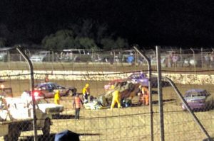 UPSIDE DOWN: Track Marshalls and safety crew tend to Kathryn Jackson after she rolled her car. PHOTO: Stuey Robinson